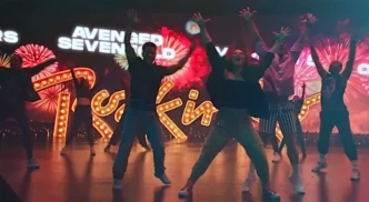 Grupo dançando em palco com luzes coloridas