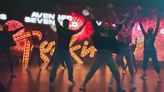 Grupo dançando em palco com luzes coloridas
