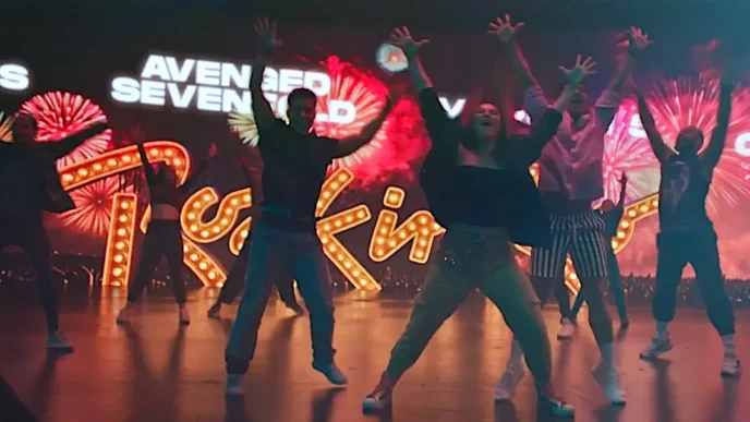 Grupo dançando em palco com luzes coloridas