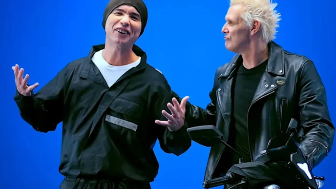 Dois homens ao lado de motocicleta fundo azul