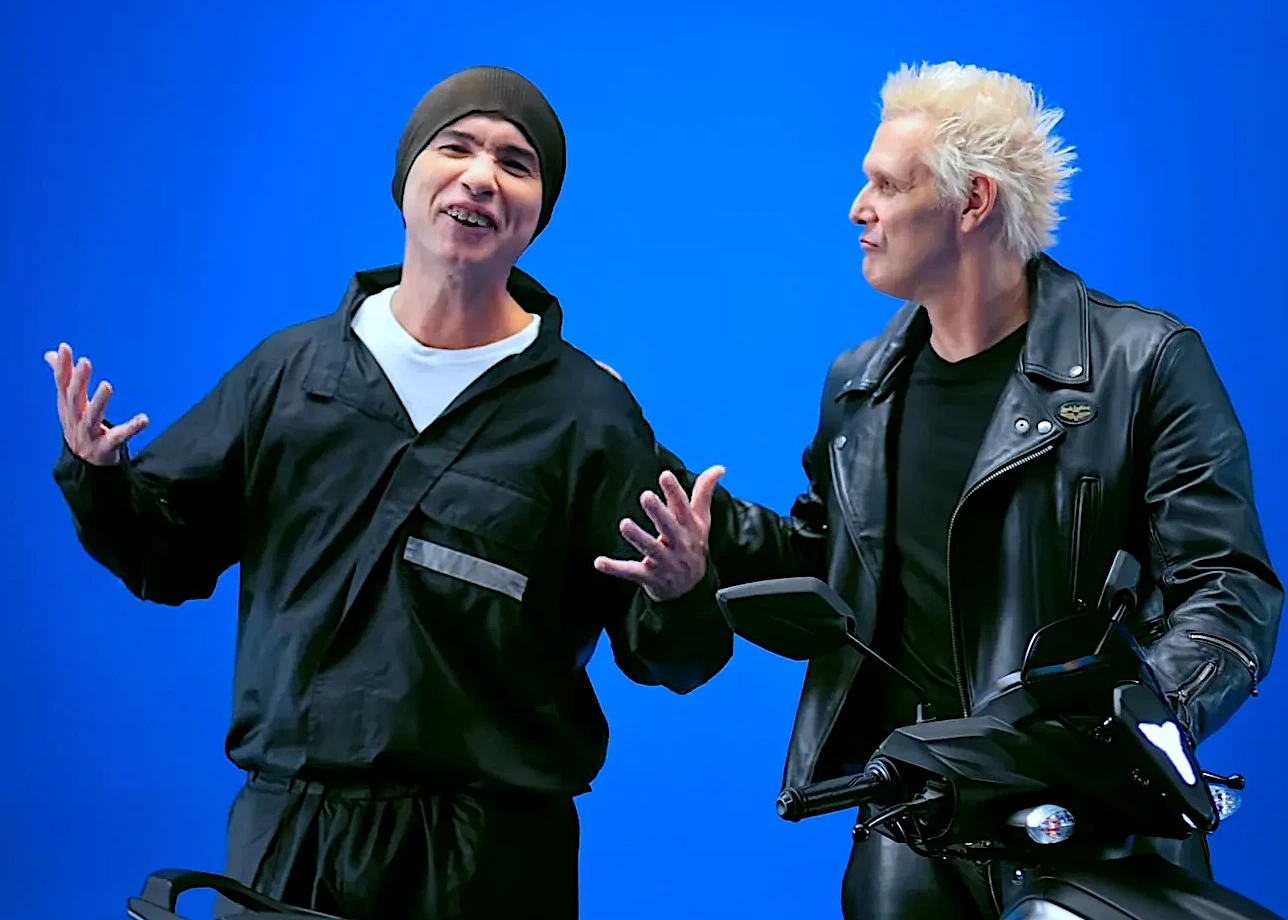 Dois homens ao lado de motocicleta fundo azul