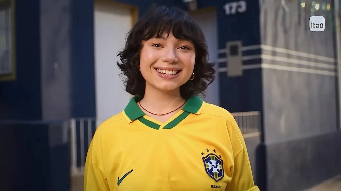 Jovem sorrindo com camisa da seleção brasileira