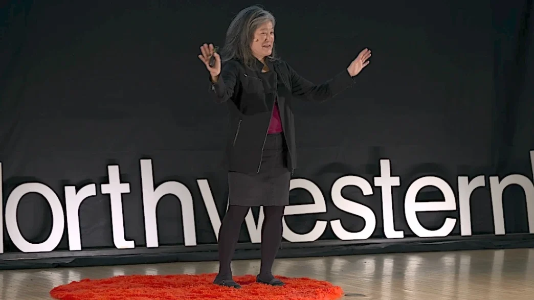 Mulher palestrando em palco com logo Northwestern