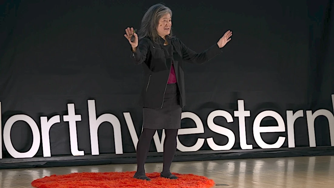 Mulher palestrando em palco com logo Northwestern