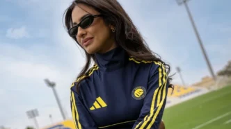 Mulher de óculos escuros em estádio de futebol
