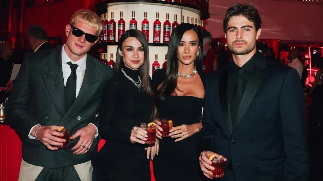 Quatro pessoas elegantes em evento com coquetéis