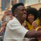 Homem sorrindo cumprimenta fãs em rua animada