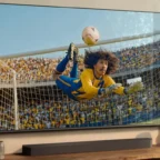 TV exibindo goleiro defendendo bola no estádio