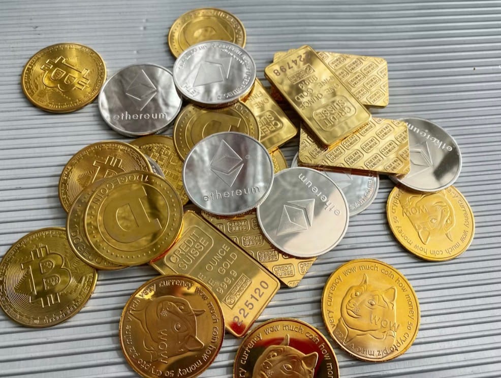 Moedas físicas de criptomoedas e barras de ouro