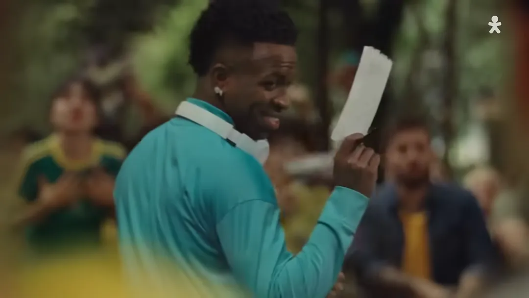 Homem sorrindo segura papel ao ar livre
