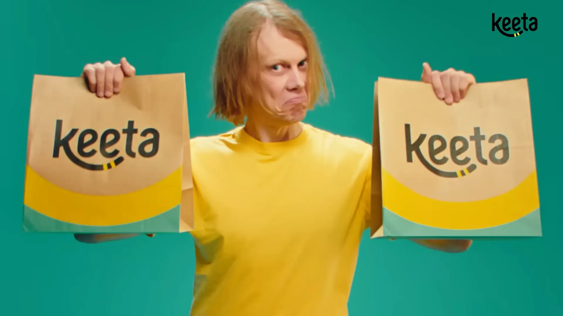 Pessoa segurando duas sacolas da Keeta