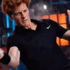 Jogador de tênis rebatendo bola em quadra indoor