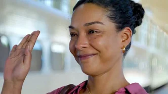 Mulher sorrindo acenando em estação de trem