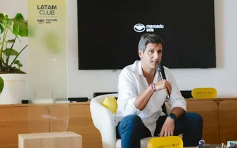Homem falando ao microfone em evento corporativo