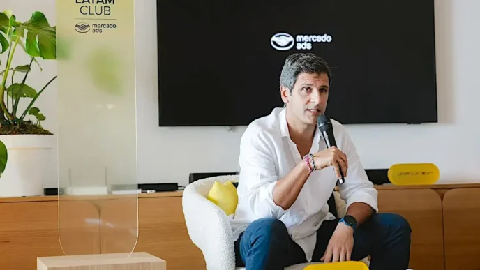 Homem falando ao microfone em evento corporativo