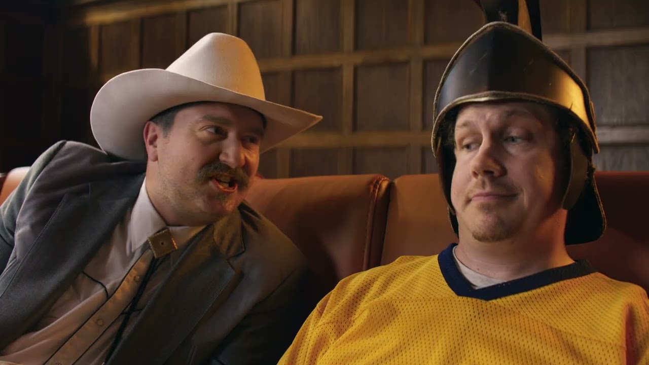 Personagens do Couch Committee da Cheez-It debatendo sobre futebol universitário em um sofá temático